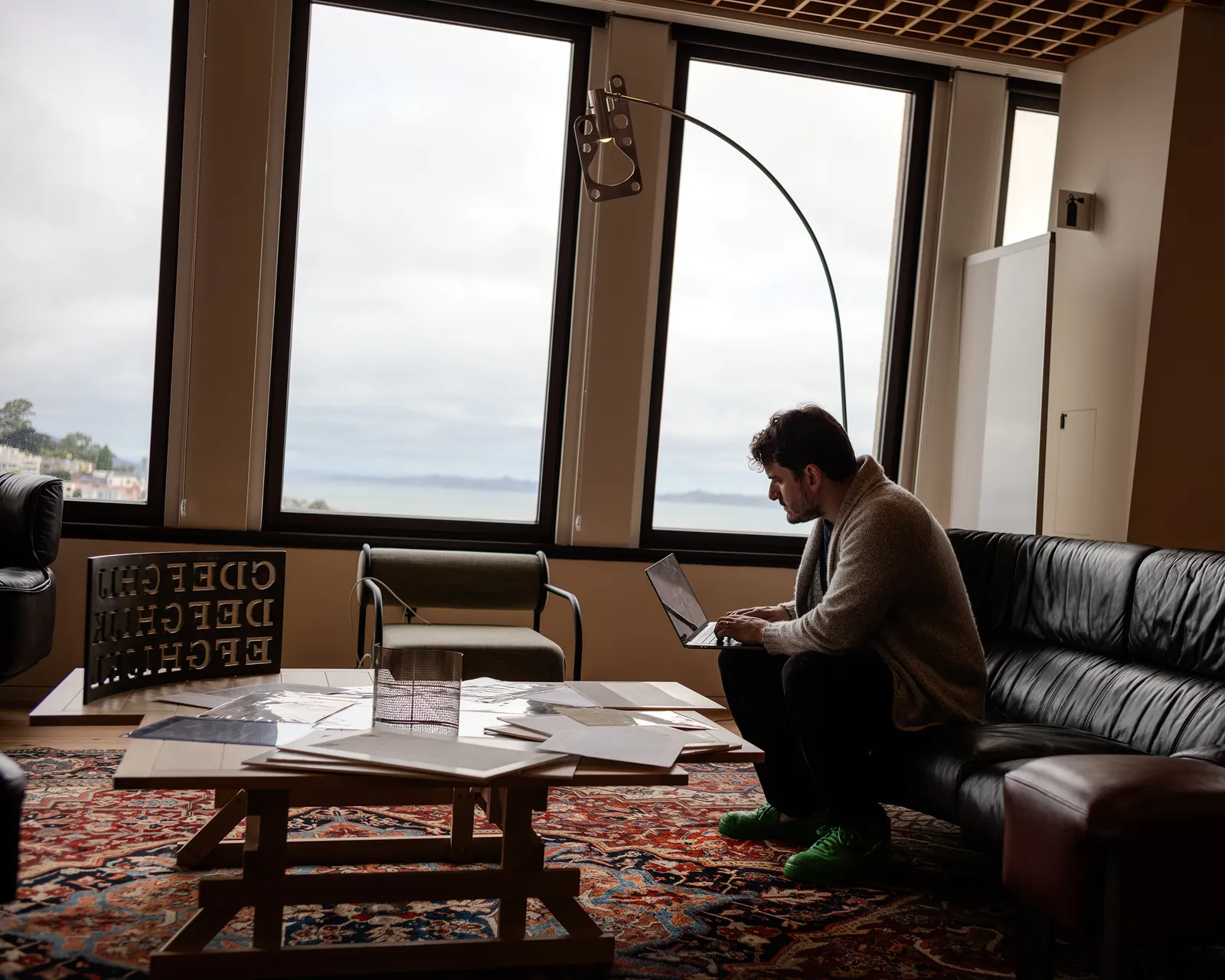 Image may contain Lamp Adult Person Chair Furniture Computer Electronics Laptop Pc Sitting Table and Floor Lamp